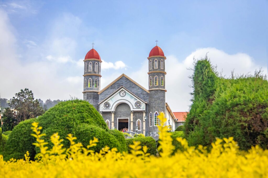 Beautiful view of Iglesia de San Rafael amidst lush gardens and blue sky.
